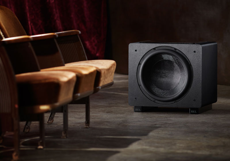 A REL Subwoofer near theater seating.